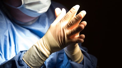 In this June 28, 2016 file photo, a doctor prepares for a surgical procedure at a hospital in Washington.