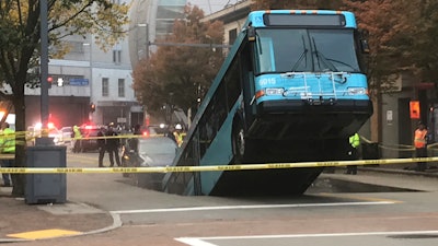 Authorities investigate after a Port Authority bus was caught in a sinkhole in downtown Pittsburgh on Monday, Oct. 28, 2019. The Port Authority of Allegheny County says the lone passenger is being treated Monday morning for minor injuries.