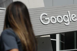 In this Sept. 24, 2019, file photo, a woman walks below a Google sign on the campus in Mountain View, Calif.