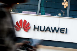 In this July 30, 2019, file photo, a woman walks by a Huawei retail store in Beijing.