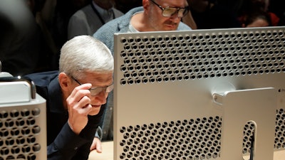 In this June 3, 2019, file photo, Apple CEO Tim Cook, left, and chief design officer Jonathan Ive look at a Mac Pro in San Jose, Calif.