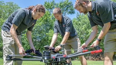Evan Beachly (from left), Jim Higgins and Carrick Detweiler assemble a drone system before taking it for a test flight.