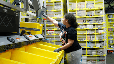 In this June 26, 2019, file photo a worker sorts through items and places orders at the Amazon Fulfillment Center in Staten Island in New York. Amazon.com Inc. reports financial earns on Thursday, Oct. 24.