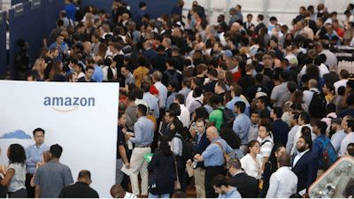 In this Sept. 17, 2019, photo job seekers line up to speak to recruiters during an Amazon job fair in Dallas. On Friday, Oct. 4, the U.S. government issues the September jobs report.