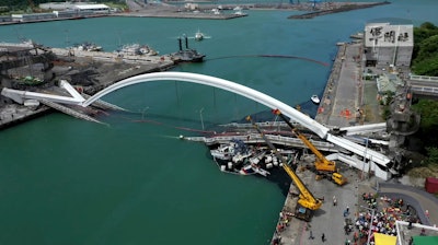 This image made from video provided by Taiwan's Military News Agency shows Nanfangao Bridge, collapsed in Nanfangao, eastern Taiwan, Tuesday, Oct. 1, 2019. The towering arch bridge over a bay collapsed Tuesday, sending a burning oil tanker truck falling onto boats in the water below.