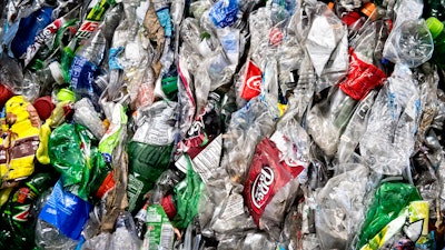 In this Nov. 15, 2016, file photo, crushed plastic bottles sit in a bale following sorting at the Mid-America Recycling plant, in Lincoln, Neb. Coca-Cola Co., PepsiCo and Keurig Dr. Pepper are investing $100 million to improve U.S. bottle recycling and processing.