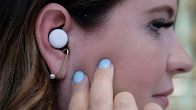 In this Tuesday, Sept. 24, 2019, photo Isabelle Olsson, head of color & design for Nest, shows Pixel buds in her ear at Google in Mountain View, Calif.