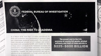 This Oct. 4, 2019 photo shows a copy of an FBI pamphlet and related emails. The FBI’s outreach to American colleges and universities about the threat of economic espionage includes this pamphlet that warns specifically about efforts by China to steal academic research.