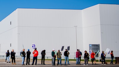General Motors' Flint Assembly Plant employees line the street with picket signs during the nationwide UAW strike against General Motors on Monday, Oct. 7, 2019, in Flint, Mich.