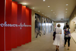 In this July 30, 2013, file photo, people walk along a corridor at the headquarters of Johnson & Johnson in New Brunswick, N.J. A Philadelphia jury has ruled that Johnson & Johnson and Janssen Pharmaceuticals must pay $8 billion in punitive damages over an antipsychotic drug linked to the abnormal growth of female breast tissue in boys. A law firm for the plaintiff released a statement Tuesday, Oct. 8, 2019, saying the companies used an organized scheme to make billions of dollars while illegally marketing and promoting the drug called Risperdal.