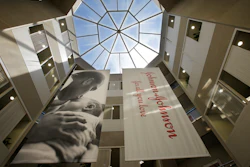 In this July 30, 2013, file photo, large banners hang in an atrium at the headquarters of Johnson & Johnson in New Brunswick, N.J. Johnson & Johnson has agreed to a $117 million multistate settlement over allegations it deceptively marketed its pelvic mesh products, which support women's sagging pelvic organs.
