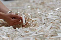 In this Friday July 26, 2019, file photo, a visitor looks through Lego pieces provided for a project at the Tate Modern, in London. Lego is testing a way for customers to ship their unwanted bricks back and get them into the hands of other kids.