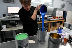 Harvey Myland prepares paint for mixing at the factory in London, Thursday, Oct. 24, 2019. Founded 135 years ago, Mylands paint factory has survived two World Wars, and now supplies film and TV productions such as 'Harry Potter'' and 'Game of Thrones,'' but Brexit is already reshaping business decisions as they increase storage and moved extra stocks to Germany.