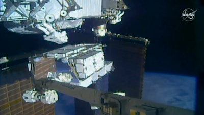 In this image made from video provided by NASA, NASA astronauts Christina Koch and Andrew Morgan work outside the International Space Station, Sunday, Oct. 6 2019. The astronauts kicked off the first of five spacewalks to replace old batteries at the International Space Station on Sunday.