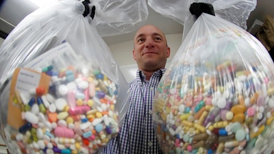 In this Wednesday, Sept. 11, 2019, file photo, narcotics detective Ben Hill, with the Barberton Police Department, shows two bags of medications that are are stored in their headquarters and slated for destruction in Barberton, Ohio. Jury selection is set to begin Wednesday, Oct. 16, 2019, in the first federal trial over the nation's opioid epidemic.