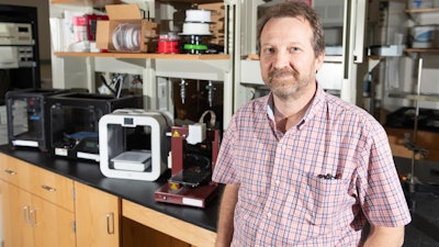 Rodney Weber, a professor in Georgia Tech's School of Earth & Atmospheric Sciences, stands in his lab alongside several consumer-grade 3D printers.