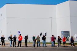 General Motors' Flint Assembly Plant employees line the street with picket signs during the nationwide UAW strike against General Motors on Monday, Oct. 7 in Flint, MI.