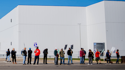 General Motors' Flint Assembly Plant employees line the street with picket signs during the nationwide UAW strike against General Motors on Monday, Oct. 7 in Flint, MI.