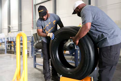 Travis Chambliss, left, and Jason Wallace unload the first tire produced at the Clinton Continental Tire Plant from a conveyor belt during the Continental Tire Grand Opening in Clinton, Miss., Wednesday, Oct. 16, 2019.