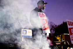 In this Sept. 27, 2019, file photo worker Omar Glover pickets outside a General Motors facility in Langhorne, Pa. A tentative four year contract with striking General Motors gives workers a mix of pay raises, lump sum payments and an $11,000 signing bonus.