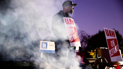 In this Sept. 27, 2019, file photo worker Omar Glover pickets outside a General Motors facility in Langhorne, Pa. A tentative four year contract with striking General Motors gives workers a mix of pay raises, lump sum payments and an $11,000 signing bonus.