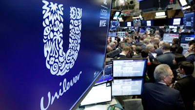 In this Thursday, March 15, 2018 file photo, the logo for Unilever appears above a trading post on the floor of the New York Stock Exchange. Consumer products giant Unilever, whose brands include Dove soaps and Lipton teas, said on Monday Oct. 7, 2019, they are pledging to halve its use of non-recycled plastics by 2025.