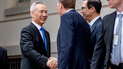 In this May 10, 2019, file photo, China's Vice Premier Liu He, left is greeted by U.S. Treasury Secretary Steve Mnuchin, second from right, and U.S. Trade Representative Robert Lighthizer, third right, as he arrives at the Office of the United States Trade Representative in Washington. China's Ministry of Commerce said Tuesday that Liu is going to Washington on Thursday for talks aimed at ending the tariff war.