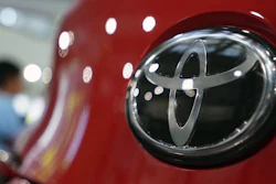In this Aug. 2, 2019, file, photo, people walk by the logo of Toyota at a show room in Tokyo.
