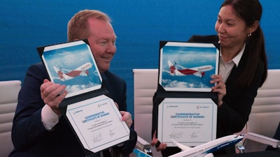 Boeing Commercial Airplanes president and CEO Stanley A. Deal, left, and Air Astana chief planning officer Alma Aliguzhinova pose at a news conference at the Dubai Airshow, Nov. 19, 2019.