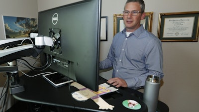 In this July 1, 2019, photo, software engineer Joe Wilson works in his home in Highlands Ranch, Colo.