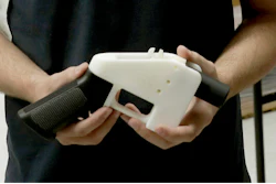 In this Aug. 1, 2018, file photo, Cody Wilson, with Defense Distributed, holds a 3D-printed gun called the Liberator at his shop, in Austin, Texas.