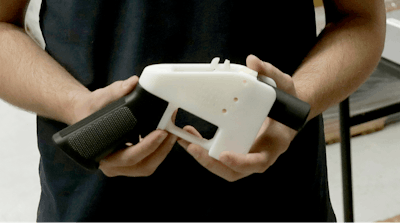 In this Aug. 1, 2018, file photo, Cody Wilson, with Defense Distributed, holds a 3D-printed gun called the Liberator at his shop, in Austin, Texas.