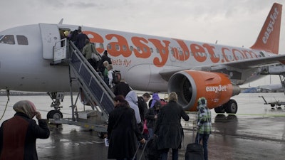 In this Oct. 18, 2012, file photo, passengers board a London-bound EasyJet flight at Amsterdam's Schiphol airport, Netherlands.