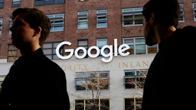 In this Dec. 4, 2017, file photo, people walk by Google offices in New York.