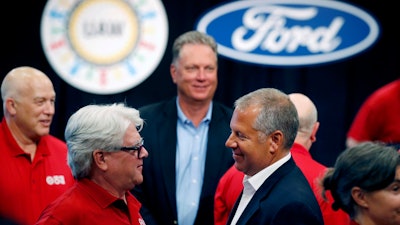 In this July 15, 2019, file photo, United Auto Workers Local 600 President Bernie Ricke, left, talks with Ford Motor Co. President-Automotive Joseph Hinrichs after opening contract talks in Dearborn, Mich.