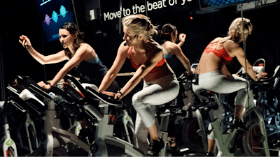 In this March 1, 2017, file photo, Jamey Powell, left, and Julianne Hough lead an exercise class as the participants are introduced to the Alta HR fitness tracker at Swerve cycling center in New York. Google’s parent company is buying wearable device maker Fitbit for about $2.1 billion. Alphabet said Friday, Nov. 1, 2019, that it will pay $7.35 per share.