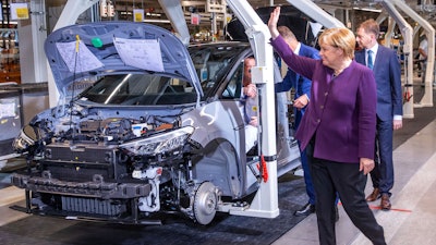 German Chancellor Angela Merkel waves to workers on the production line for ID.3 in Zwickau, Nov. 4, 2019.