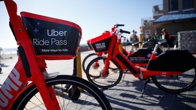 In this May 28, 2019, file photo, Jump electric bike-share bicycles by Uber are seen along Mission Beach boardwalk in San Diego.