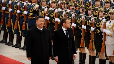Chinese President Xi Jinping, left, and French President Emmanuel Macron review an honor guard during a welcome ceremony at the Great Hall of the People in Beijing, Nov. 6, 2019.