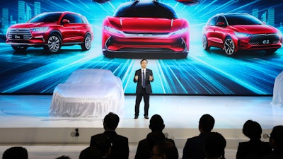 In this April 16, 2019, file photo, Wang Chuanfu, chairman and president of BYD Auto, prepares to show the latest cars during Auto Shanghai 2019.