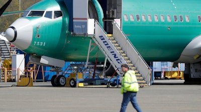 In this April 26, 2019, file photo, a worker walks past a Boeing 737 Max 8 airplane at Boeing's assembly facility in Renton, Wash.