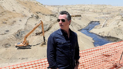 In this July 24, 2019, file photo, Gov. Gavin Newsom tours the Chevron oil field, where a spill of more than 800,000 gallons flowed into a dry creek bed, in McKittrick, Calif.