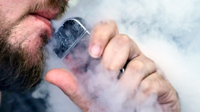 In this Oct. 4, 2019, file photo, a man using an electronic cigarette exhales in Mayfield Heights, Ohio.