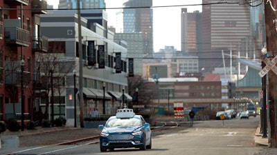 In this Dec. 18, 2018, file photo, one of the test vehicles from Argo AI, Ford's autonomous vehicle unit, navigates through the strip district near the company offices in Pittsburgh.