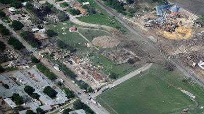 This April 18, 2013, aerial photo shows the remains of a nursing home, left, apartment complex, center, and fertilizer plant, right, destroyed by an explosion at a fertilizer plant in West, Texas.