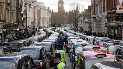 In this Feb. 10, 2016, file photo, taxis block the roads during a protest in central London about unfair competition from ride-sharing services.