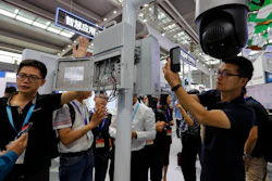 In this Oct. 29, 2019, photo, visitors look at the 5G mobile station and a surveillance camera by China's telecoms equipment giant Huawei at the China Public Security Expo in Shenzhen.