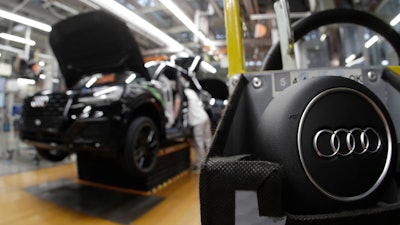 In this March 24, 2018, file photo, part of the assembly line at German car producer Audi plant in Ingolstadt, Germany. The Ingolstadt-based automaker said Tuesday Nov. 26, 2019, that it expected to add 2,000 new positions while Volkswagen subsidiary Audi says it is cutting 9,500 jobs in Germany through 2025.
