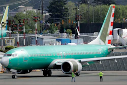 In this May 8, 2019, file photo workers stand near a Boeing 737 MAX 8 jetliner being built for American Airlines prior to a test flight in Renton, Wash. American Airlines CEO Doug Parker says his airline is feeling more confident that its grounded Boeing 737 Max jets will soon be approved to fly again.
