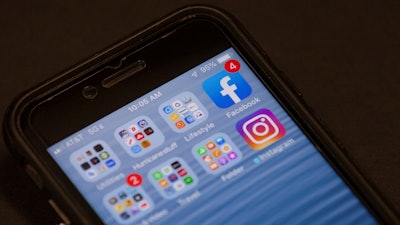 In this Oct. 29, 2019, file photo, a Facebook app is shown on a smartphone in Miami. Facebook said Wednesday, Nov. 13, that it removed 3.2 billion fake accounts from its service from April to September, up slightly from 3 billion in the previous six month.